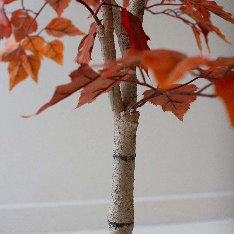 Artificial tree with red leaves on a plain background